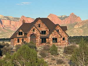 Tudor house featuring a mountain view, a chimney, and stone siding