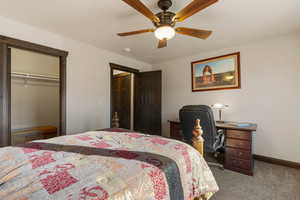 Carpeted bedroom with a closet and ceiling fan
