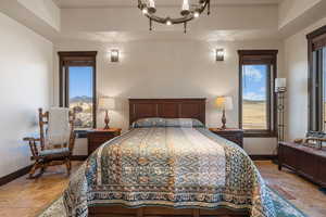 Bedroom featuring hanging lights and stone finish flooring