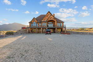 View of front of house with a mountain view, stone siding, and a chimney