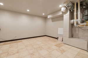 Finished below grade area with recessed lighting and heating unit