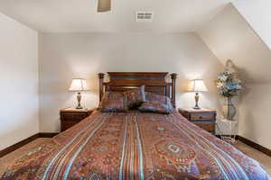 Carpeted bedroom with ceiling fan and vaulted ceiling