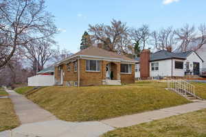 View of front facade featuring brick siding and a chimney