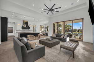 Living area featuring parquet floors, ceiling fan, recessed lighting, and a high ceiling