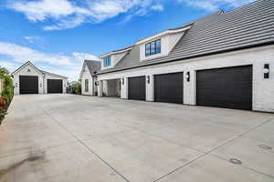 View of property exterior featuring a garage and concrete driveway