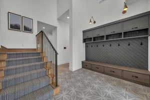 Mudroom with a high ceiling and recessed lighting