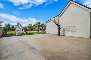 View of patio / terrace with a playground and basketball hoop