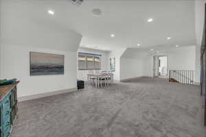Empty room with light carpet and recessed lighting