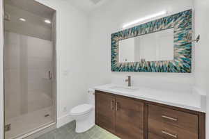 Bathroom featuring vanity, a stall shower, light tile patterned flooring, and recessed lighting