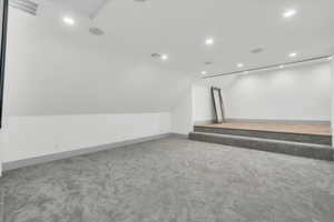 Additional living space with light carpet, vaulted ceiling, and recessed lighting