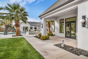 Doorway to property featuring french doors, an outdoor pool, stucco siding, and a patio area