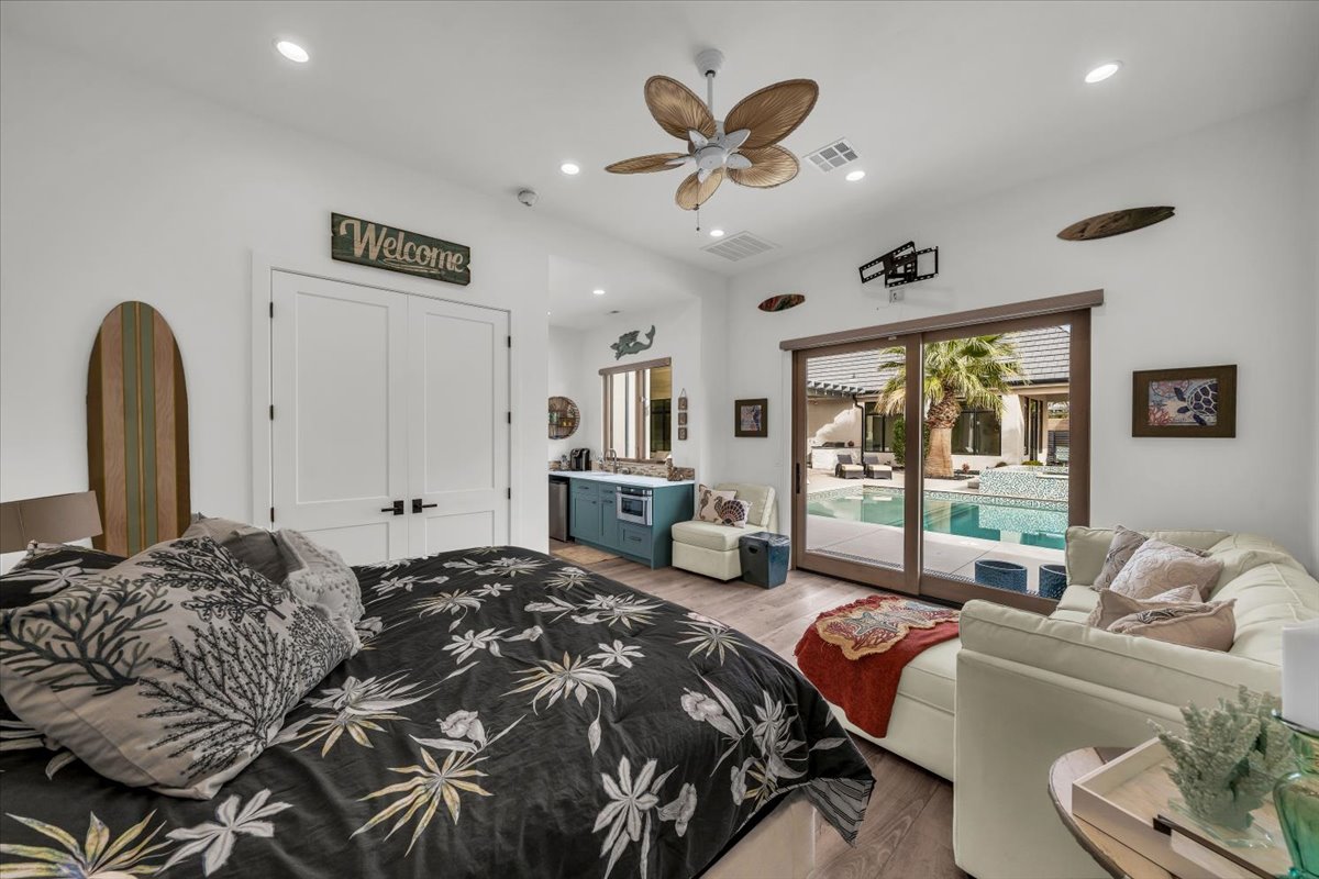 Bedroom with access to exterior, wood finished floors, recessed lighting, ceiling fan, and a closet
