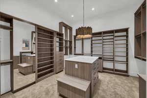 Walk in closet featuring light colored carpet and a chandelier