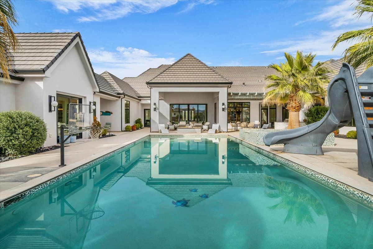 Swimming pool with a water slide and a patio area