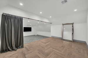 Unfurnished room featuring vaulted ceiling, parquet flooring, and recessed lighting