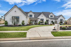 View of front facade with a front lawn, a porch, and stucco siding