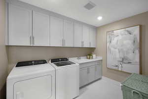 Laundry room featuring independent washer and dryer and cabinet space
