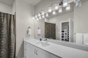 Bathroom featuring vanity, curtained shower, and a spacious closet