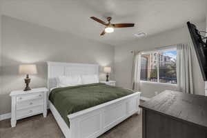 Carpeted bedroom featuring baseboards and a ceiling fan