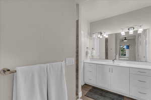 Full bath featuring vanity, light wood-style floors, and a ceiling fan