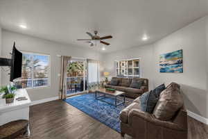 Living area featuring dark wood-style flooring, ceiling fan, and recessed lighting