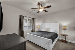 Carpeted bedroom featuring baseboards and ceiling fan