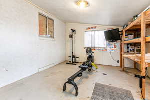 Workout room featuring concrete flooring and vaulted ceiling