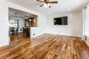 Unfurnished living room featuring a ceiling fan, light wood-style floors, and recessed lighting