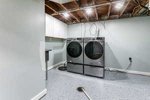 Laundry room with washing machine and clothes dryer, cabinet space, and speckled floor