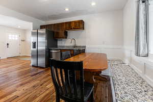 Dining space with dark wood-type flooring and recessed lighting
