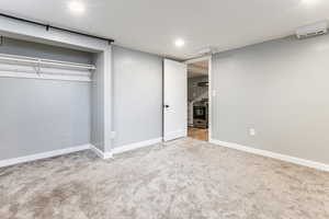 Unfurnished bedroom with light colored carpet, recessed lighting, and a closet
