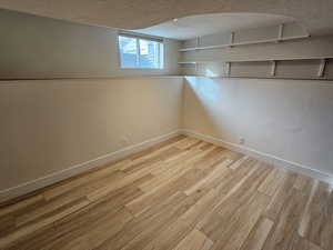 Below grade area featuring a textured ceiling and light wood-type flooring