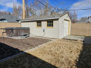 View of outbuilding featuring concrete driveway and a hot tub