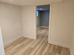 Empty room with light wood-style floors and a textured ceiling