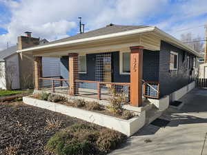 View of front of house featuring brick siding and covered porch