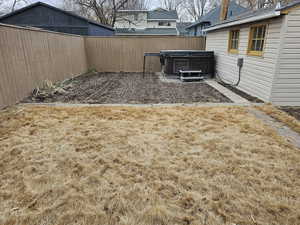 Fenced backyard featuring a patio area and a hot tub