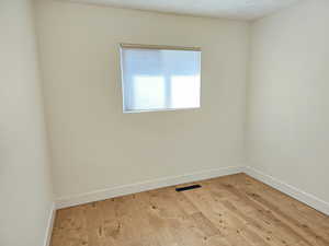 Unfurnished room with light wood-type flooring and baseboards