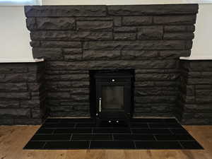 Detailed view of wood finished floors and a wood stove