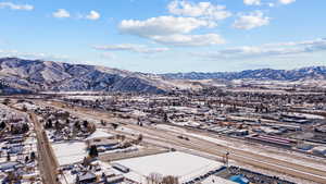 Snowy aerial view featuring a mountain view and a residential view
