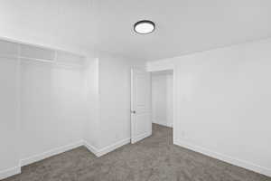 Unfurnished bedroom with carpet floors and a textured ceiling
