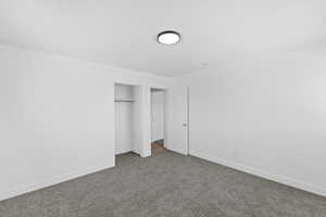 Unfurnished bedroom with carpet and a closet