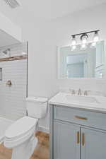 Full bath with vanity, a shower stall, and light wood-style floors