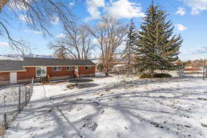 Snow covered property featuring brick siding