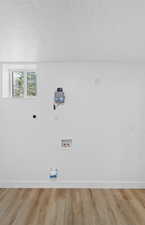 Laundry room featuring a textured ceiling, light wood finished floors, hookup for a washing machine, and hookup for an electric dryer