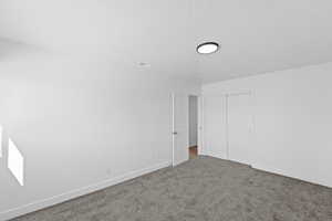 Unfurnished bedroom with carpet and a closet