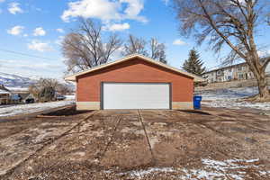 Snow covered garage with a detached garage