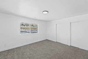 Unfurnished bedroom featuring carpet flooring and two closets