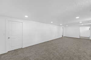 Below grade area with carpet flooring, recessed lighting, and a textured ceiling