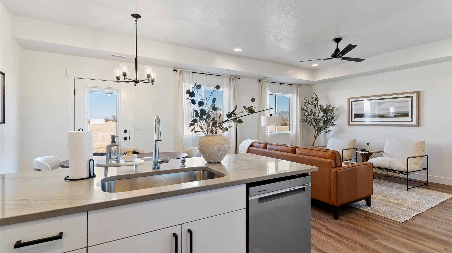 Kitchen featuring white cabinets, light stone counters, open floor plan, dishwasher, and a ceiling fan
