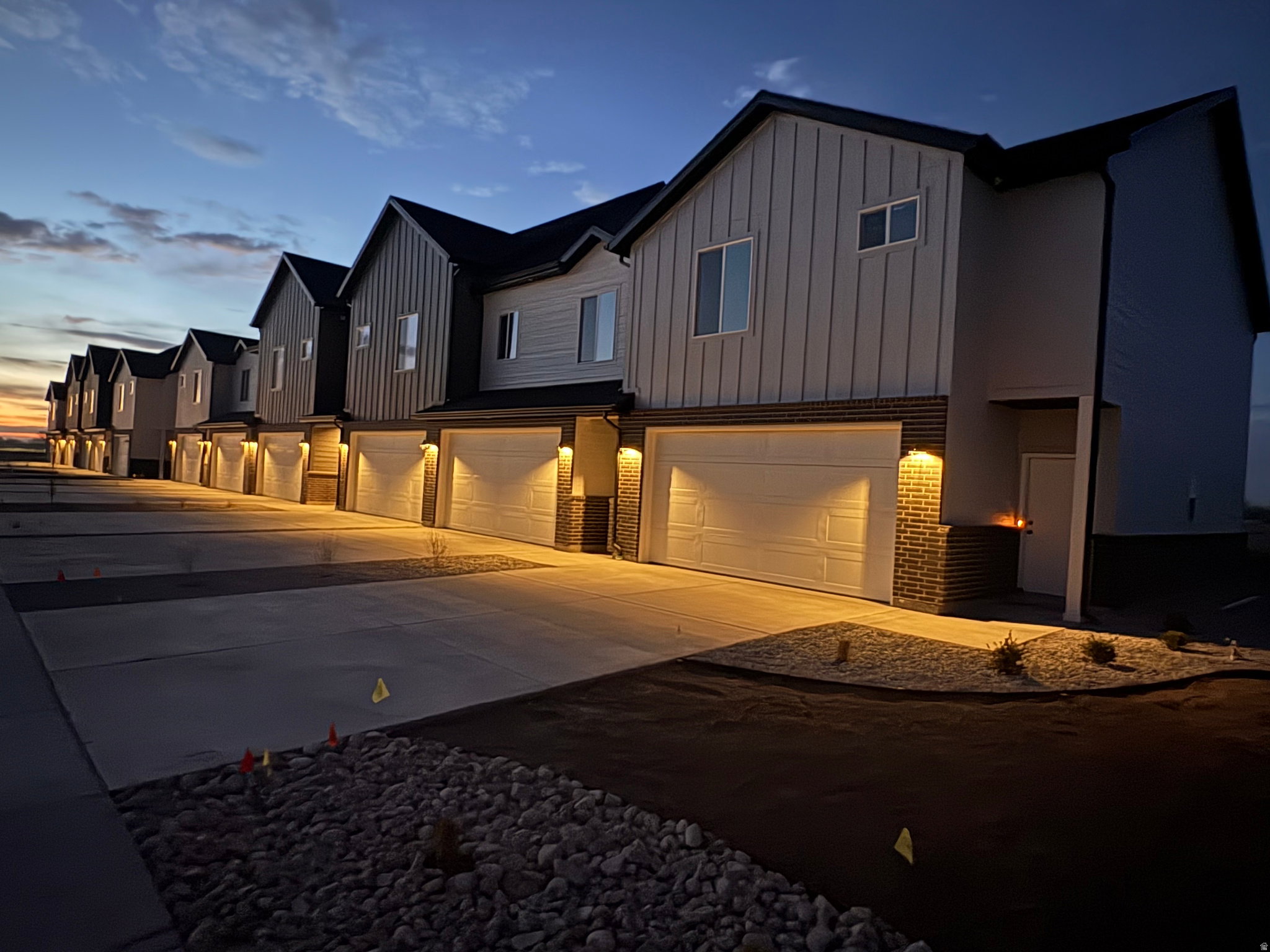 Modern farmhouse style home with board and batten siding, a garage, concrete driveway, and brick siding